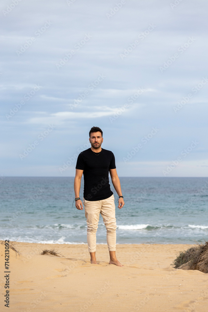 Man possing barefoot on the beach