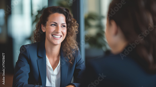 American Female Office Worker in Suit and Glasses Attending Job Interview with Hiring Manager in Modern Office Setting