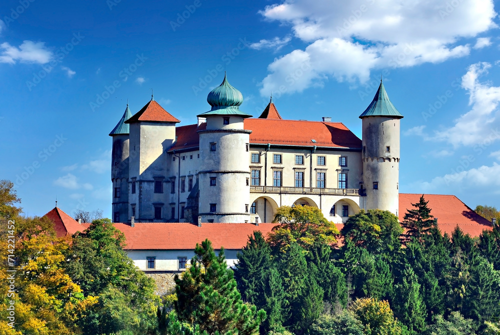 View on castle Nowy Wisnicz in Poland in sunny autumn day on a background of blue sky with white clouds - obrazy, fototapety, plakaty 