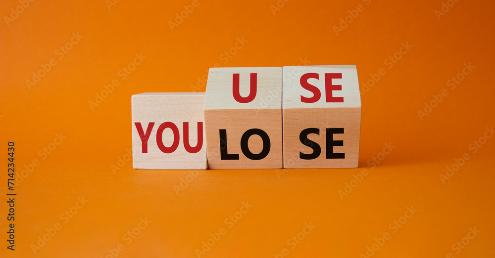 You use or lose symbol. Turned wooden cubes with words You lose or You use. Beautiful orange background. Business and You use or lose concept. Copy space You use or lose symbol. Turned wooden cubes with words You lose or You use. Beautiful orange background. Business and You use or lose concept. Copy space