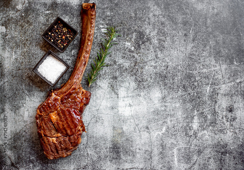 Grilled Tomahawk steak on stone background with copy space for text

