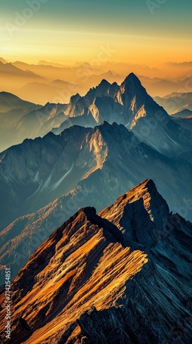 A breathtaking mountain range under the spell of sunset, with the sky in a gradient of orange to blue and the peaks highlighted in golden light