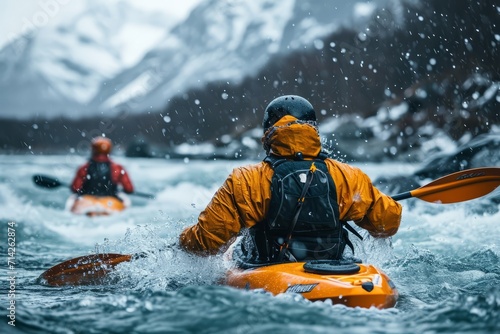 Two companions descending a whitewater river by kayak, surrounded by snow-capped mountains. Concept adventure, sport