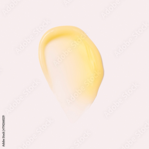 Swatch of yellow cream texture retinol, cosmetics for face and body on a isolated beige background