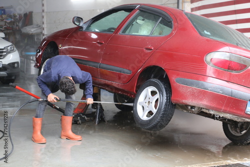 Fotografia washing the underside of the car at the car mechanic