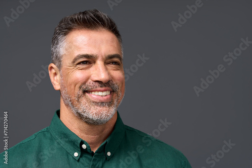 Happy middle aged business man entrepreneur, smiling mature professional confident businessman leader investor wearing green shirt looking aside isolated on gray, headshot close up portrait. photo