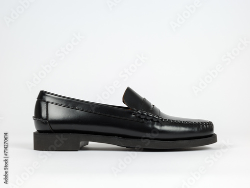 Mens shoes product photography on a white backdrop. Pack shot side view of a classic black leather loafer with rubber sole. Classic and stylish footwear for men.