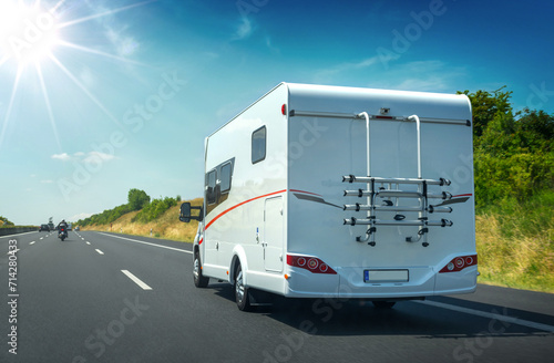 Wohnmobil mit Fahrradträger von hinten auf deutscher Autobahn im Sommer Gegenlicht – Motor home on german highway in backlit