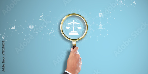 Law. Businessman Hand holding a magnifying glass with Legal Icon on Light Blue background. Legal Research, Compliance, Justice System. photo