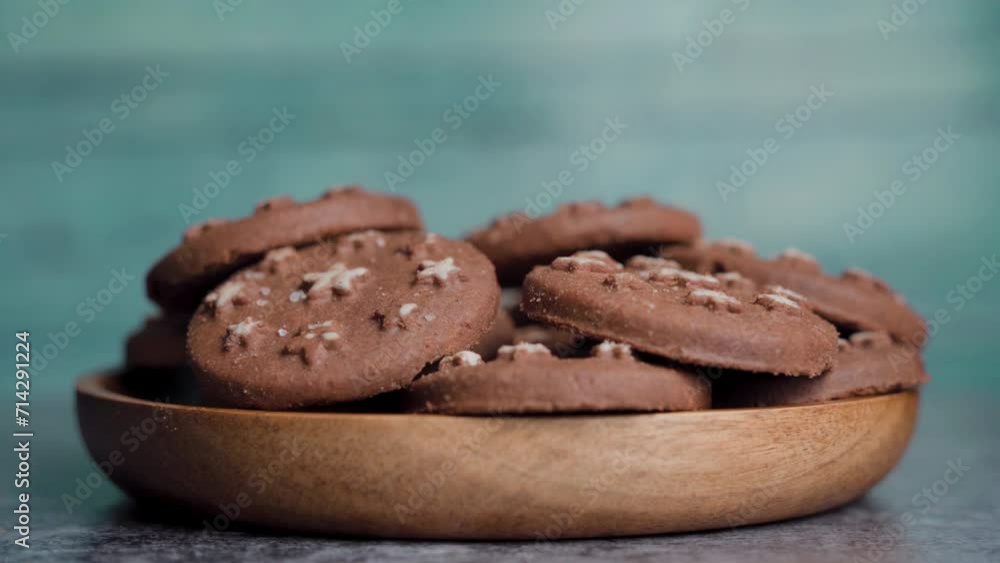 Delicious sweet cocoa cookies biscuits on a wooden plate spinning. Delicious sweet cocoa cookies biscuits on a wooden plate spinning.