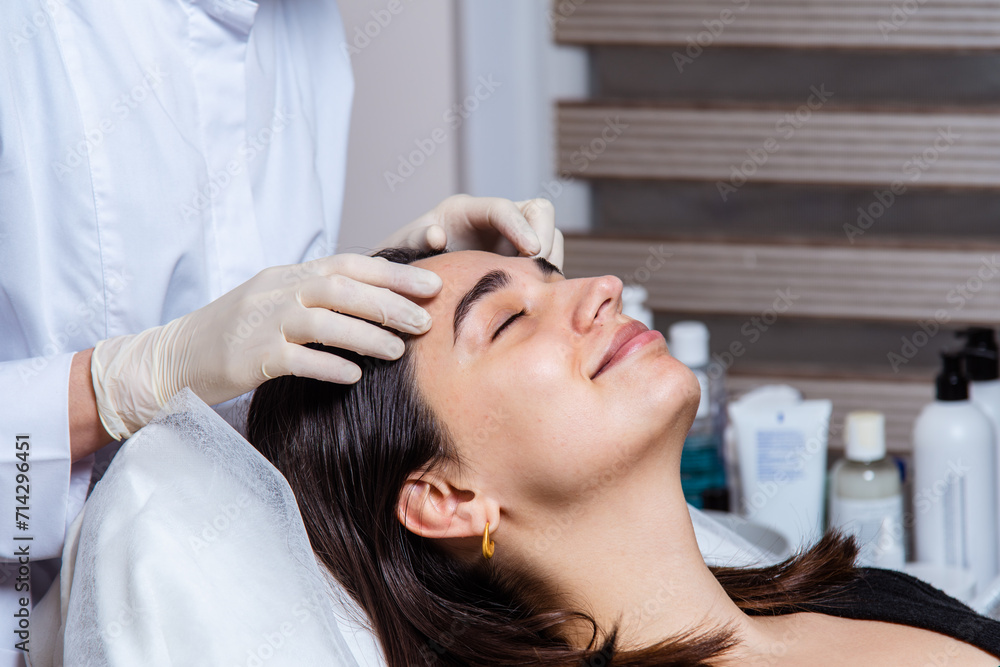 Face and decollete relaxing and lifting massage with oil in the spa office