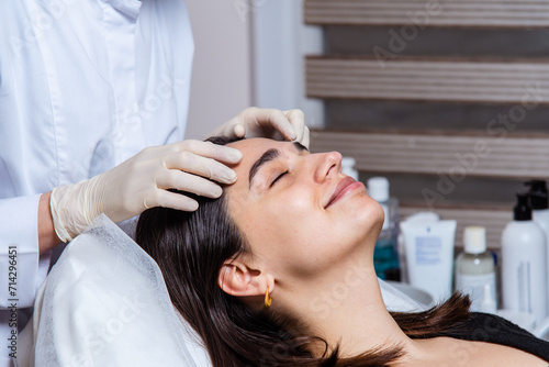 Face and decollete relaxing and lifting massage with oil in the spa office