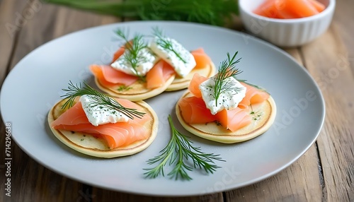 Mini blini pancakes with soft cheese, cold smoked salmon and dill