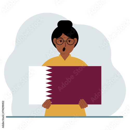 A woman is holding the flag of Qatar in his hands. The concept of demonstration, national holiday or patriotism. Nationality.