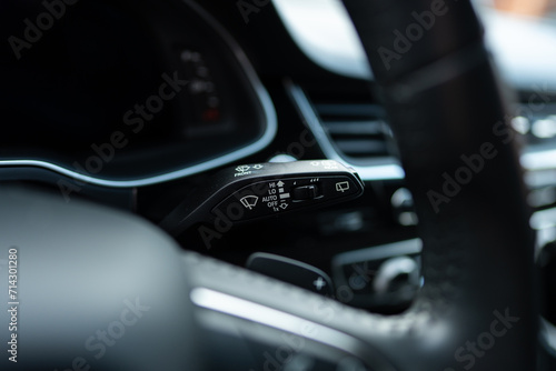 Selective focus of right turn signal lever being mounted on steering column inside modern vehicle. Car blinker switch activating direction indicator lights  © port-o