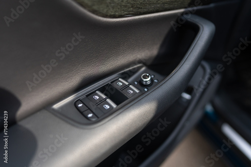 Close up view of car's window regulator switches on front door panel of brand new vehicle. Adjustment buttons on driver's side for remote control