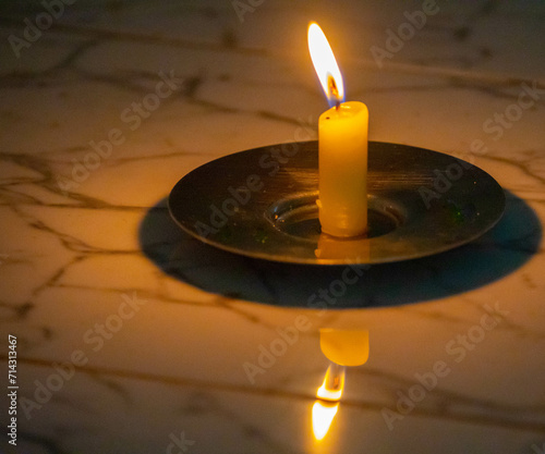 Lighted candle in a relaxing setting of faith and meditation