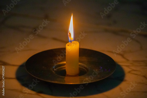 Lighted candle in a relaxing setting of faith and meditation