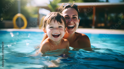 A happy child playing in the pool together with mother.