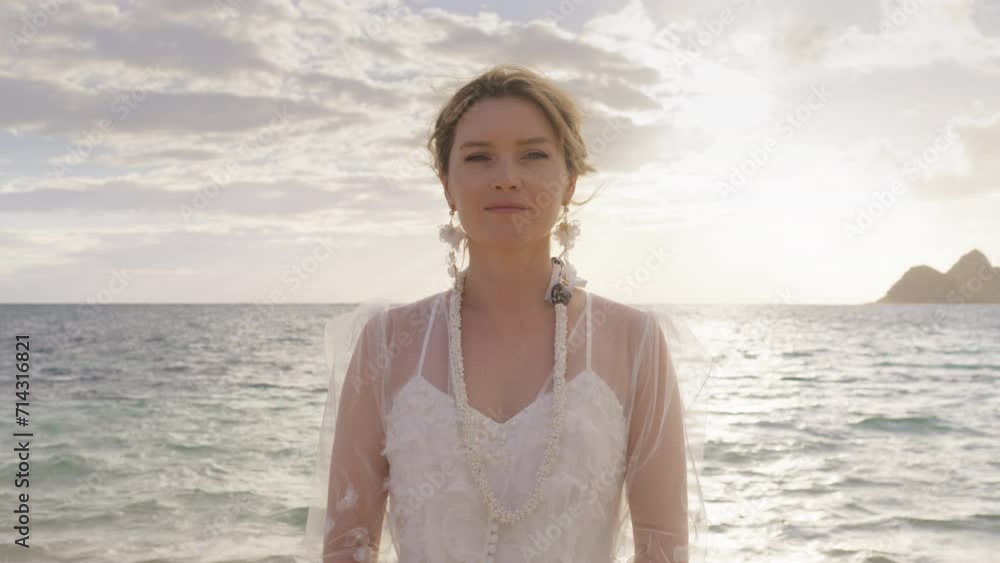 Portrait of attractive bride with relaxed stylish hairdo hair and beautiful smile 4K. Happy face young woman in trendy boho style floral wedding with hawaiian necklace looking at camera on ocean beach Portrait of attractive bride with relaxed stylish hairdo hair and beautiful smile 4K. Happy face young woman in trendy boho style floral wedding with hawaiian necklace looking at camera on ocean beach