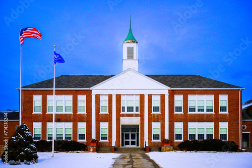 Bethel Town Hall Municipal Government Office on a snowy day in Bethel, Connecticut, with American and State Flags waving over the rooftop against the blue sky
