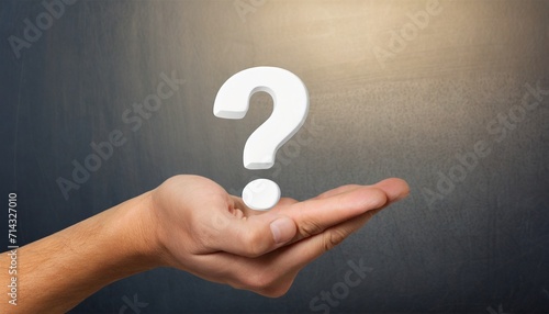 hand holding a white question mark symbol against a background