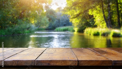empty wooden table on blurred river and forest bench background
