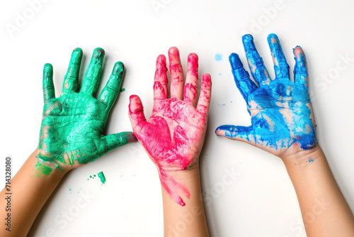 Three children's hands covered in blue, green, and pink paint, raised to support awareness for Rare Disease Day..