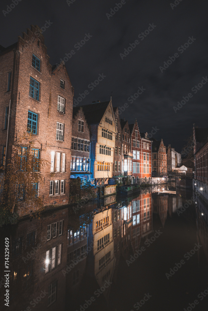 View of classic medieval houses reflected in a water canal in the centre of Ghent, Flanders region, Belgium. Colourful facades of the houses of rich citizens