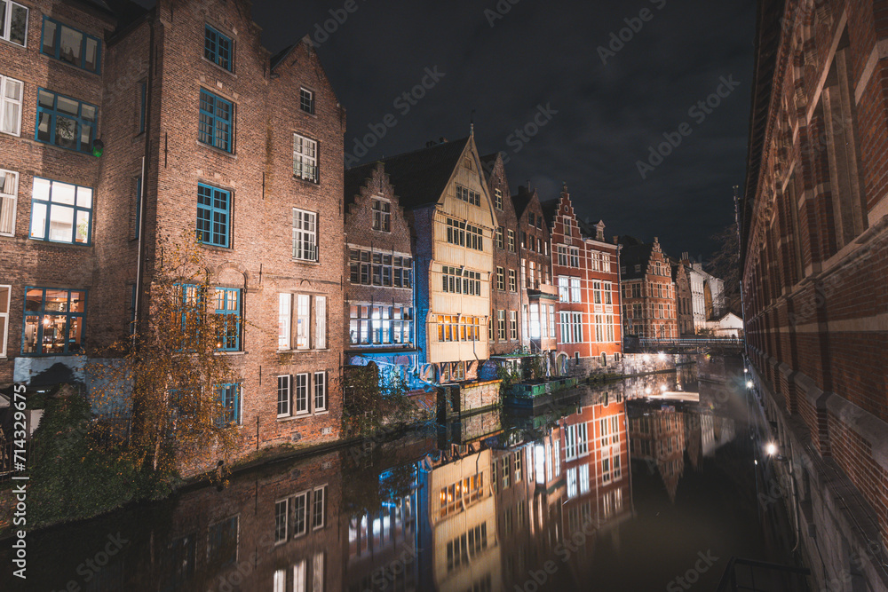 View of classic medieval houses reflected in a water canal in the centre of Ghent, Flanders region, Belgium. Colourful facades of the houses of rich citizens