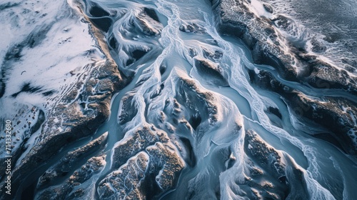  an aerial view of a body of water with ice on the water and snow on the rocks on the side of the water and in the middle of the water.