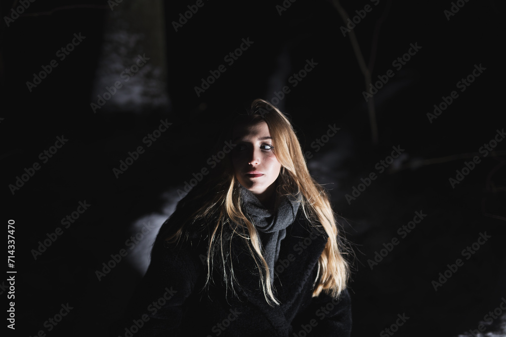 Young blond Woman with black dress in the wood at an snowstorm in deep winter at berlin forrest Young blond Woman with black dress in the wood at an snowstorm in deep winter at berlin forrest