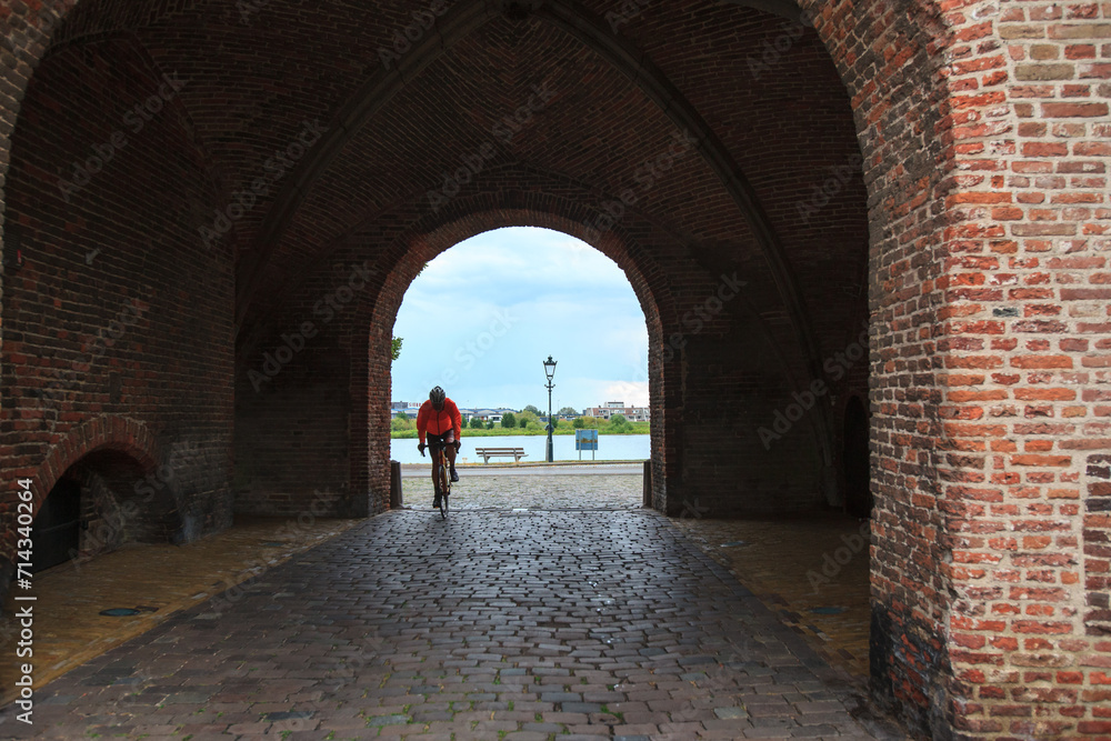 A cyclist passes through an arch