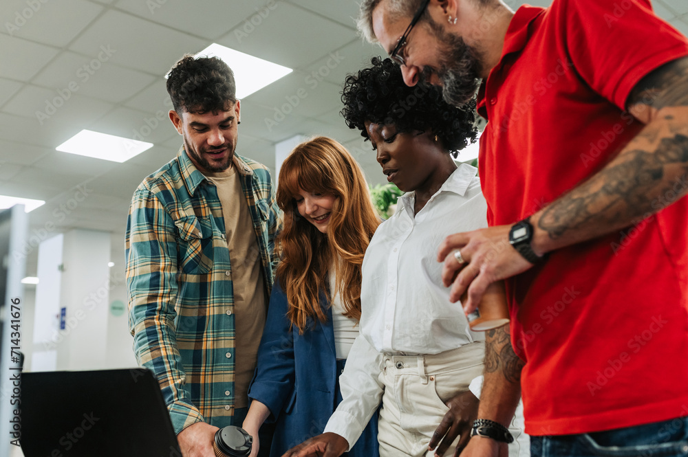 Obraz premium Portrait of diverse team looking at laptop at the office.