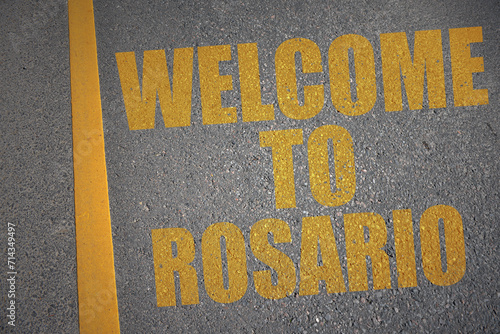 asphalt road with text welcome to Rosario near yellow line. photo