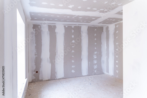 Interior of a house under renovation with drywall installation and joint compound application photo