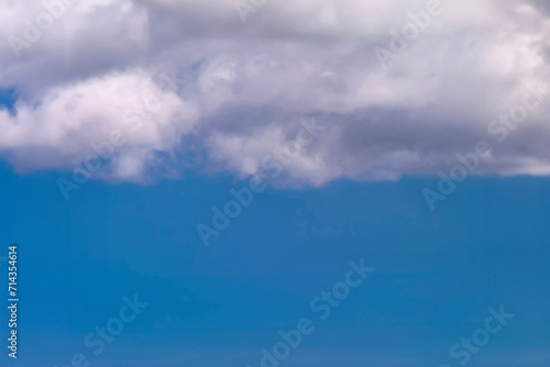 White clouds on top of the image with clear blue sky in the middle and on the bottom of the image