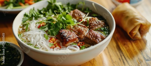 BBQ meat in Vietnamese noodle soup with spring roll, vermicelli, and veggies (known as 'Bun Cha' in Vietnam).