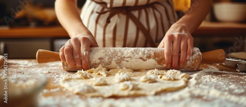 A woman uses a rolling pin to flatten dough.