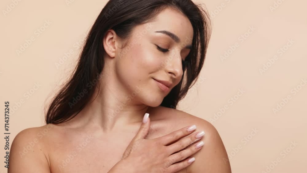 Elegant brunette woman applying cream on her shoulder, depicting beauty and skincare routines. Perfect for wellness and cosmetics themes. Elegant brunette woman applying cream on her shoulder, depicting beauty and skincare routines. Perfect for wellness and cosmetics themes.