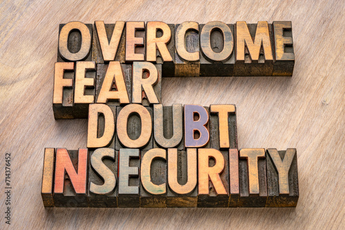 overcome fear, doubt, insecurity - inspirational words in vintage letterpress wood type, personal development concept photo