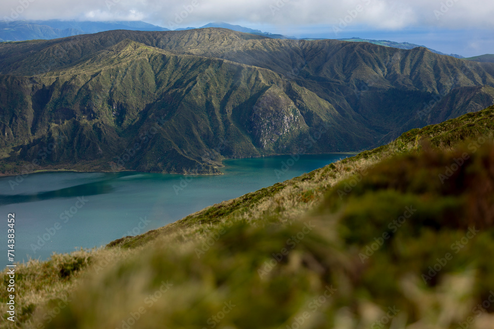 View of the Lagoa do Fogo (Fire Lagoon) Crater with the mountain range in the background. Sao Miguel island, Azores Archipelago, Portugal.