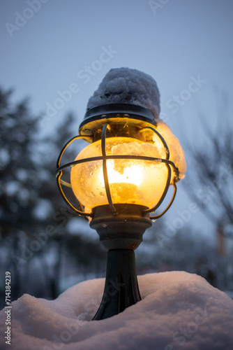 There is a lot of snow piled up on the outside lamp.