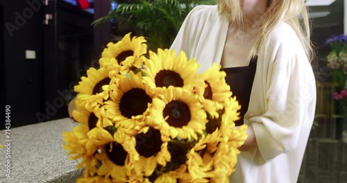  florist in a flower store shows sunflowers