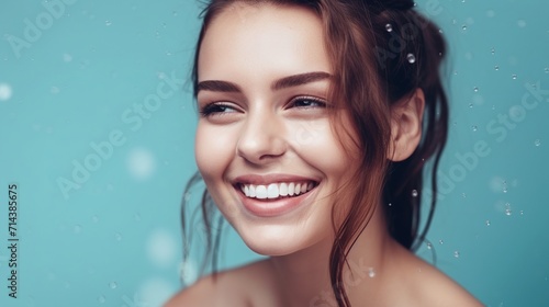 Portrait of a beautiful young woman smiling on a blue background © Denis Agati