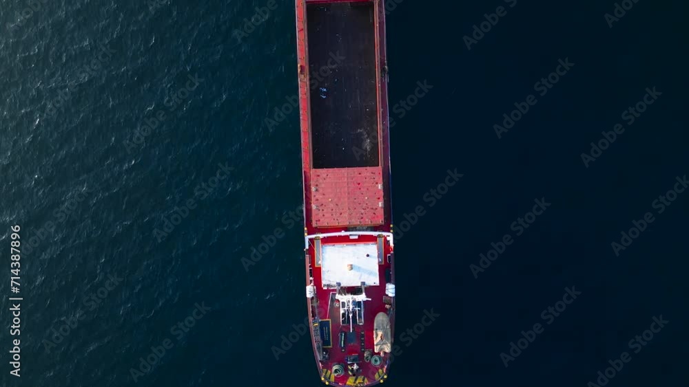 Top view of an empty cargo carrier ship on the sea. The sea is dark blue. Wireless telecommunication system is on. Top view of an empty cargo carrier ship on the sea. The sea is dark blue. Wireless telecommunication system is on.