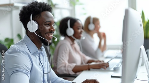 Call center employees wearing headset using computer, busy service phone operators sitting at shared desk, assistance teamwork concept. Man and woman operators talking on headset with clients.
