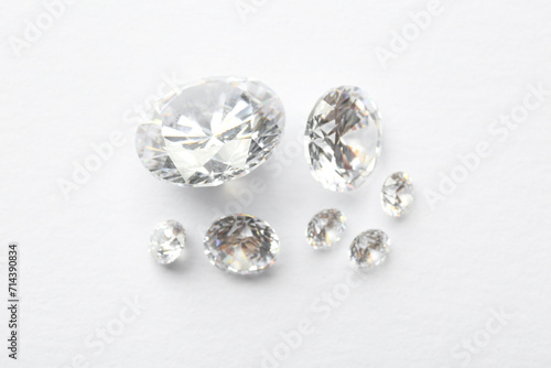 Many beautiful shiny diamonds on white background  flat lay