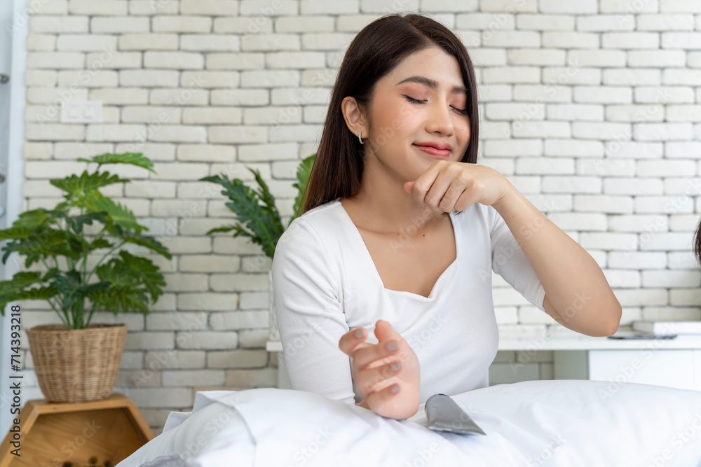 Woman smelling hand cream while relaxing in bedroom, skincare regimen concept, female enjoying aroma of moisturizer Woman smelling hand cream while relaxing in bedroom, skincare regimen concept, female enjoying aroma of moisturizer