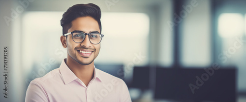 Bellissimo uomo di 30 anni di origini indiane sorride in ufficio con camicia elegante photo
